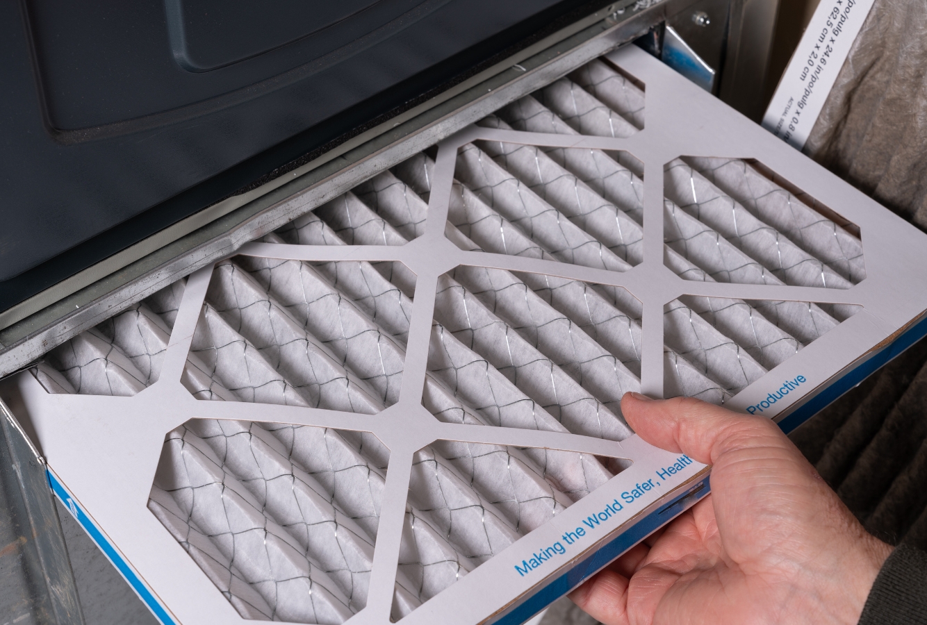 Hand changing HVAC air filter for winter efficiency. Looking for professional HVAC maintenance near me? Follow these HVAC maintenance tips in Sacramento, CA.